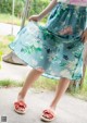 A woman wearing a skirt with a floral print on it.