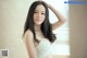 A woman in a white bra and panties posing for a picture.