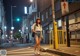 A woman walking down the street at night. 