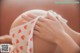 A pregnant woman wearing a strawberry print bra.